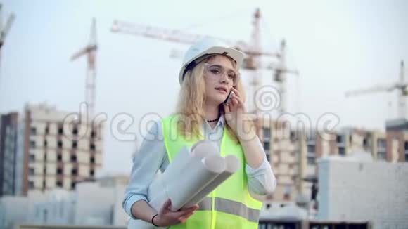 女工程师设计师与承包商通电话他们手里拿着建筑背景图视频的预览图