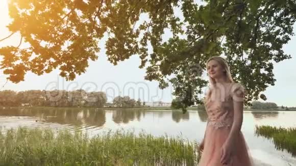 美丽的年轻金发女人在湖边的户外肖像视频的预览图