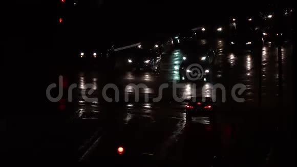 暴风雨过后夜间驾车穿过城市十字路口的交通视频的预览图