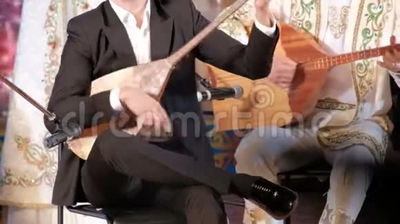 哈萨克斯坦的音乐男性音乐家演奏多姆布拉哈萨克民族乐器和服装音乐会表演视频的预览图