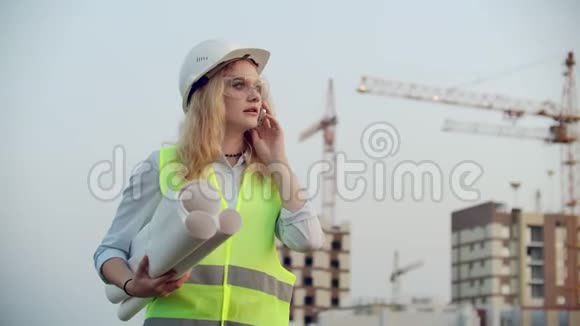 女工程师设计师与承包商通电话他们手里拿着建筑背景图视频的预览图