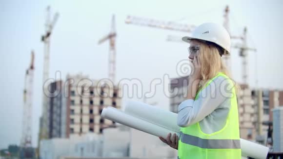 电话对话一名戴头盔的妇女在建筑背景下与主任讨论视频的预览图