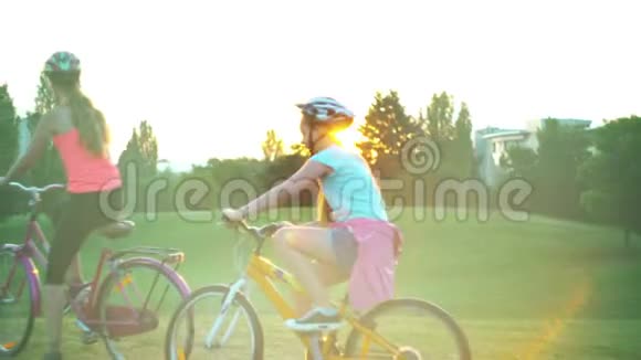 骑自行车的儿童头戴头盔夏季公园太阳升起时敬礼视频的预览图