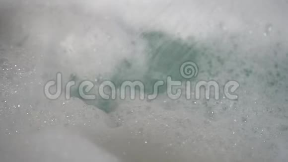 一名男子在一股淋浴水下洗去手上的新鲜泡沫视频的预览图