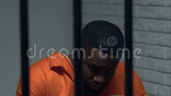 被囚禁在囚室里的非裔美国囚犯思考犯罪悲伤视频的预览图