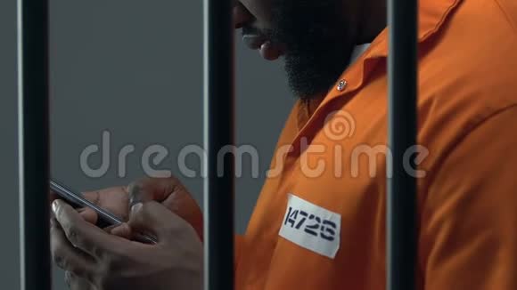 非裔美国人囚犯在智能手机上滚动监狱里被禁止的物品视频的预览图