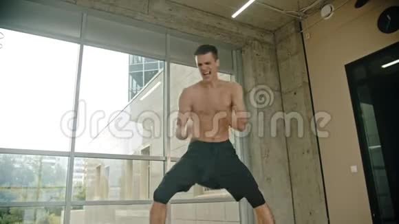 一名运动男拳击手站在窗边用一种力量进行了一场影子耐力训练视频的预览图