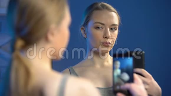 玩的青少年做鬼脸用智能手机照镜子自拍视频的预览图