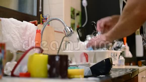 一个人洗碗旁边是一大堆脏盘子双手特写没有脸视频的预览图