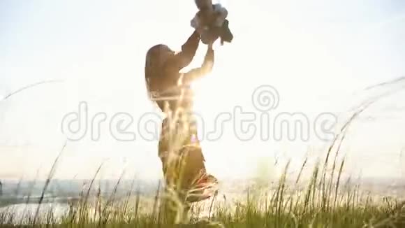 女人和孩子玩旋转和微笑在夕阳的天空背景上视频的预览图