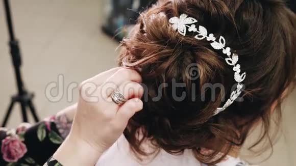 发型师给她的头发剪直造型师手特写坐着化妆的女孩视频的预览图