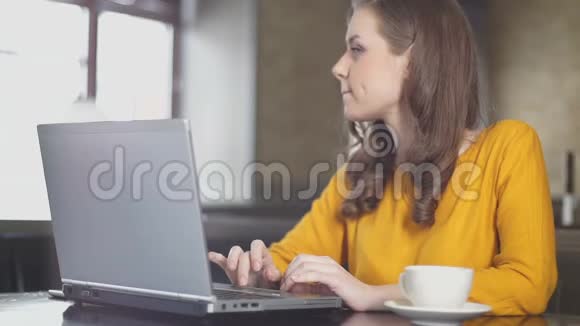 启发女作家思考新书在咖啡馆的笔记本电脑上工作视频的预览图