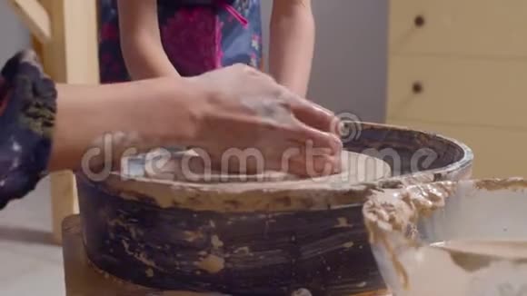 在陶工轮子上做锅的漂亮女孩视频的预览图