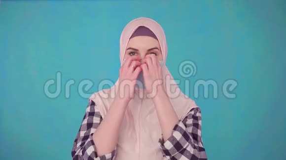 年轻美丽的穆斯林女性戴着医用面具微笑着摘下面具看着镜头视频的预览图