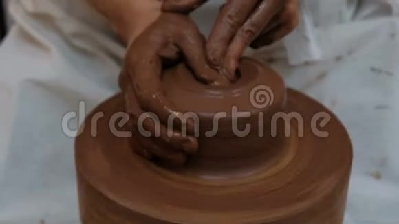粘土容器的生产手工女性的手在陶轮上形成棕色的产物古老的制作工艺视频的预览图