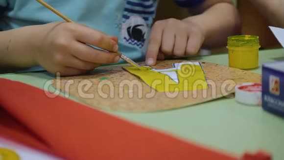幼儿在纸上画出鲜艳的颜色桌子上的油漆这孩子手很大小艺术家发展视频的预览图