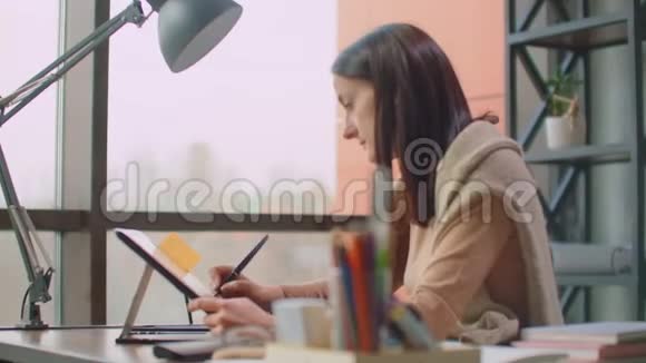 女平面设计师手工使用互动笔显示数字绘图平板和笔在电脑上在办公室视频的预览图