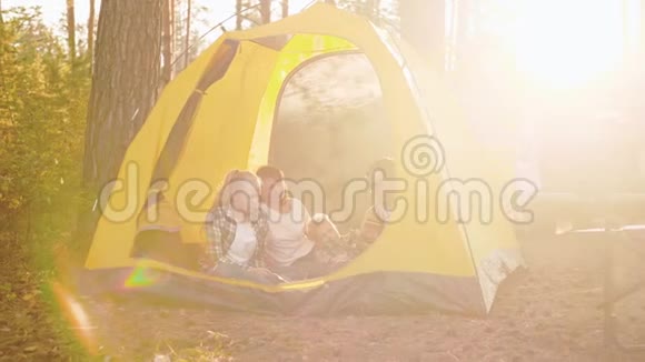 在森林的帐篷里坐着吉他的幸福家庭视频的预览图