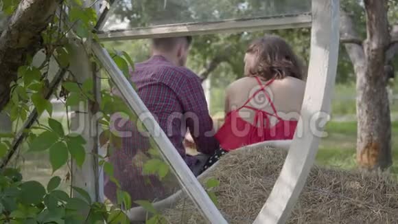 男人和女人坐在花园里男人拥抱他的女朋友情绪化的女人告诉她男朋友视频的预览图