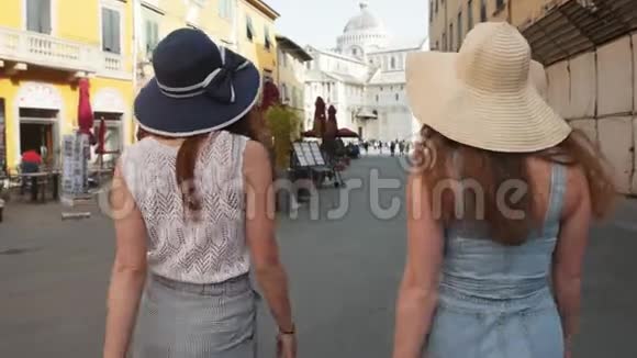 意大利比萨两个年轻的女人在咖啡馆的街道上穿着睡衣散步视频的预览图