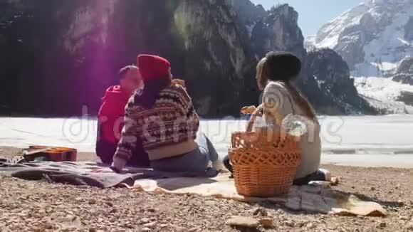 年轻人旅行坐在海岸边吃面包聊天视频的预览图