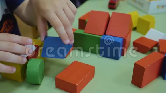 孩子们手在桌子上收集明亮的木块特写逻辑思维学前儿童的发展视频的预览图