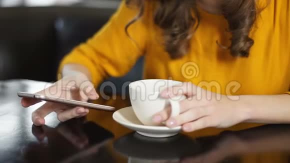 女人在咖啡馆喝咖啡使用智能手机在社交网络聊天视频的预览图