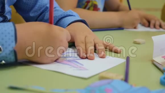 幼儿在幼儿园做图纸手的儿童特写孩子们创造力团队合作视频的预览图
