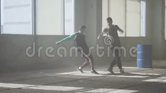 两个成功舞者的朋友正在一座废弃的尘土飞扬的建筑里跳舞当代的嘻哈文化视频的预览图