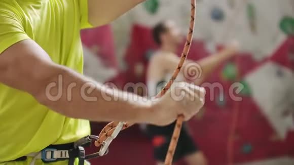 他用绳子打另一个登山者年轻运动员用绳子打嗝看另一个登山者的俯视图视频的预览图