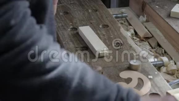 男木匠用弯曲的尺子和木匠把木板标记在松木架子上视频的预览图