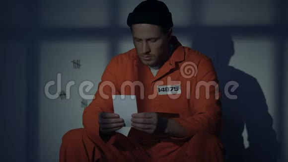 沮丧的白种人囚犯接吻照片失踪的爱人服刑视频的预览图