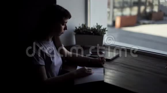 一个年轻女子用铅笔在纸上画的左手视频的预览图