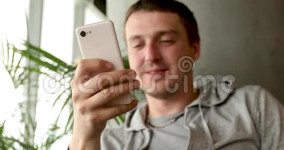 手拿智能手机微笑的男人视频的预览图