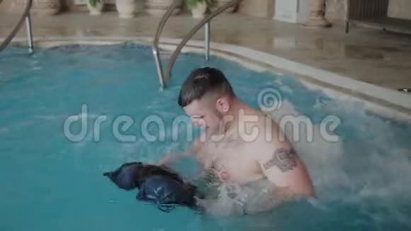 快乐有趣的男人在泳池按摩浴缸里洗澡洗他的短裤视频的预览图