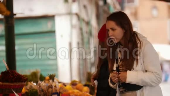 两个年轻的女人在外面的市场上散步寻找异国情调的糖果视频的预览图