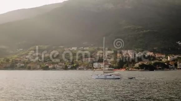 这艘游艇正在黑山的亚得里亚海航行背景是美丽的山脉视频的预览图
