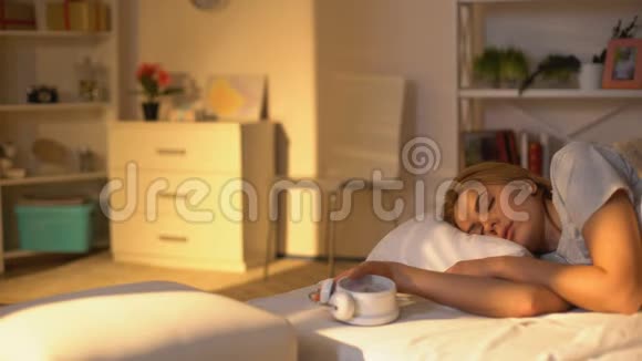 年轻女子手中的钟从床上跳起来上班迟到睡过头视频的预览图