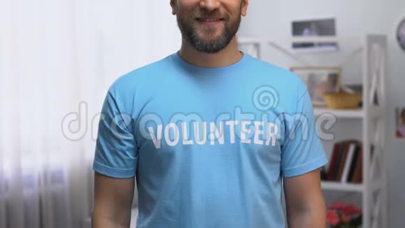 自信的人穿着t恤带着志愿者的名字微笑着对着镜头支持视频的预览图