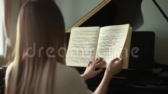女钢琴演奏家双手翻动音符动作缓慢视频的预览图