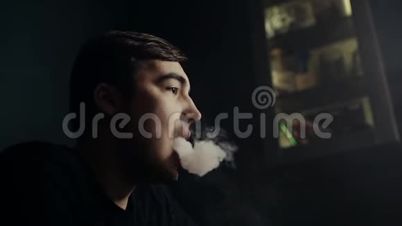 在黑暗的胡克房里用慢动作吹着烟圈的帅哥视频的预览图