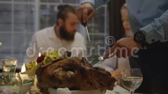 在节日晚餐上雕刻火鸡的人视频的预览图