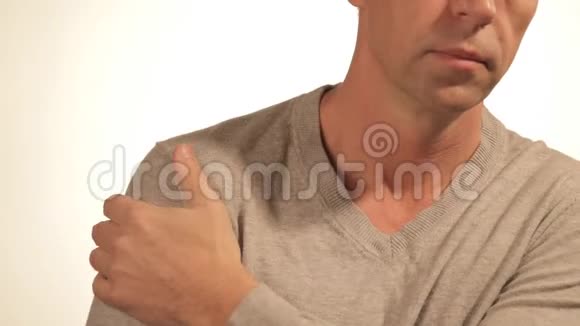 男人按摩他疼痛的肩膀试图减轻疼痛的白色背景健康问题视频的预览图