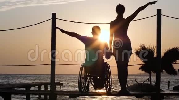 轮椅上有病腿的男人和女朋友在阳光明媚的夕阳下进行浪漫的旅行视频的预览图