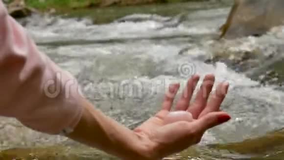雌性手拿着玫瑰石英水晶玉蛋在河底女性健康与自然观念的统一视频的预览图