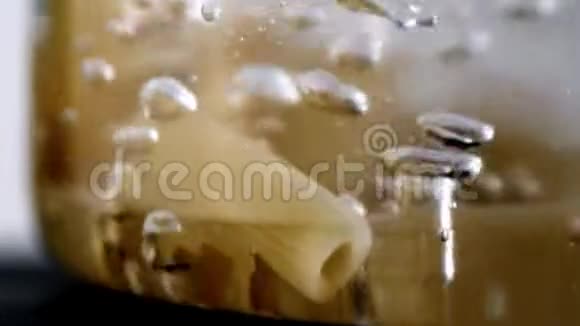 用透明平底锅在热水中煮面用慢动作的宏观视角烹饪视频的预览图