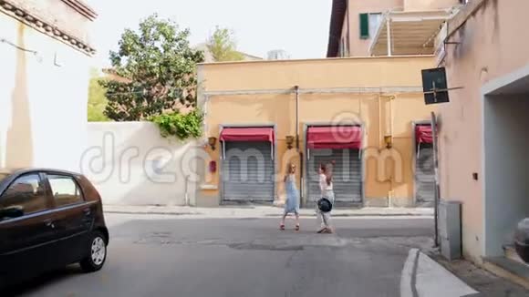 两个年轻的旅行快乐的女人站在黄色的街道上视频的预览图