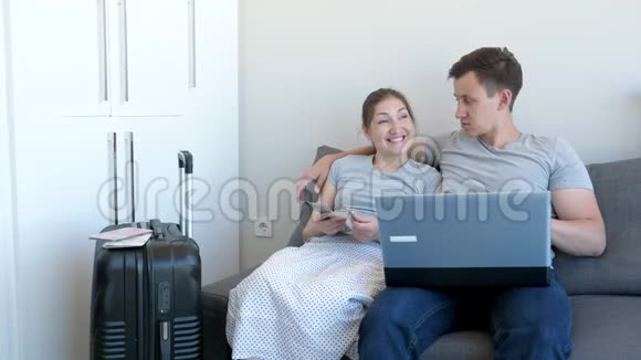 男人和女人要去旅行在家里坐在沙发上拿钱视频的预览图