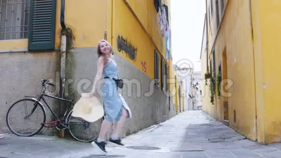 两个年轻的旅行快乐的女人带着行李走在黄色的墙壁上视频的预览图