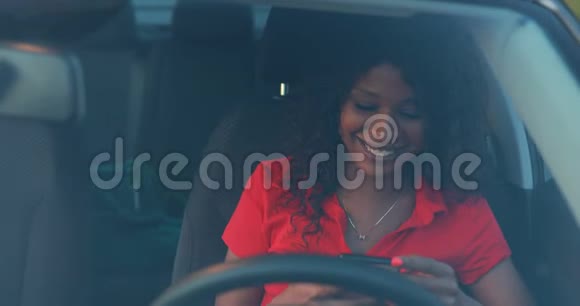 女人用智能手机坐在车里发信息视频的预览图